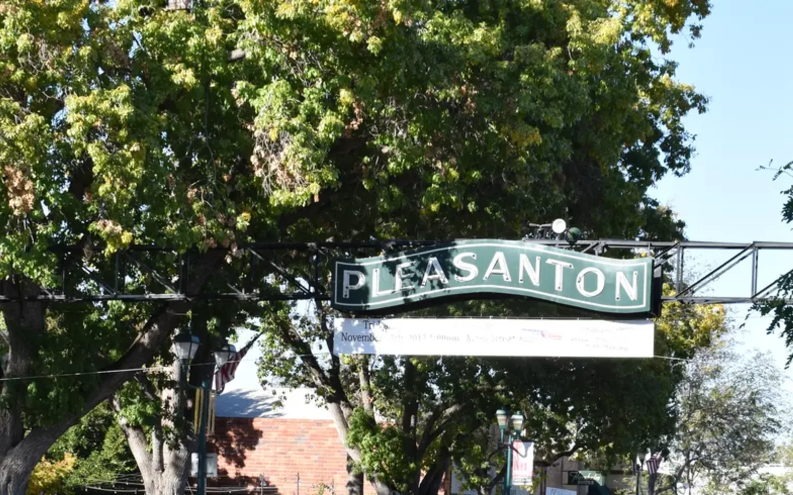 Pleasanton’s downtown entry sign framed by street trees.